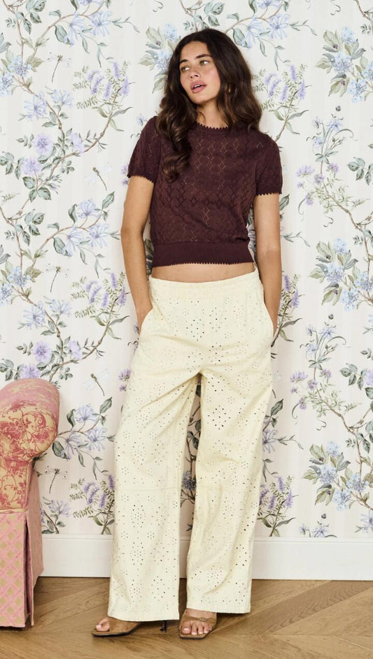 Image of a model wearing Pants. Product name - Relaxed Fit Cotton Denim Broderie Pant in Cream colour by brand - MINKPINK