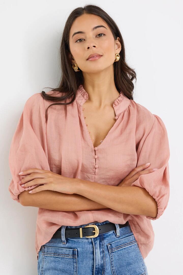 Image of a model wearing Tops. Product name - Closure Blush Ramie High Neck Buttoned SS Top in Blush colour by brand - Ivy + Jack