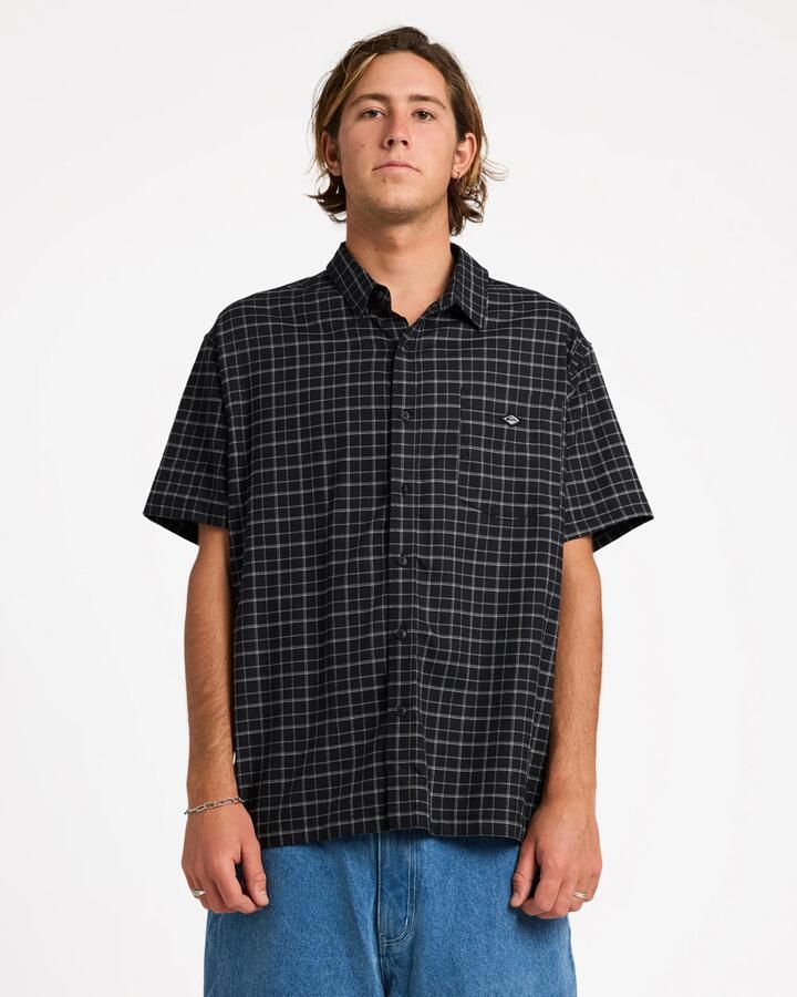 Image of a model wearing Tops. Product name - Quiksilver Mens Liquid Short Sleeve Shirt Black in Black colour by brand - Quiksilver
