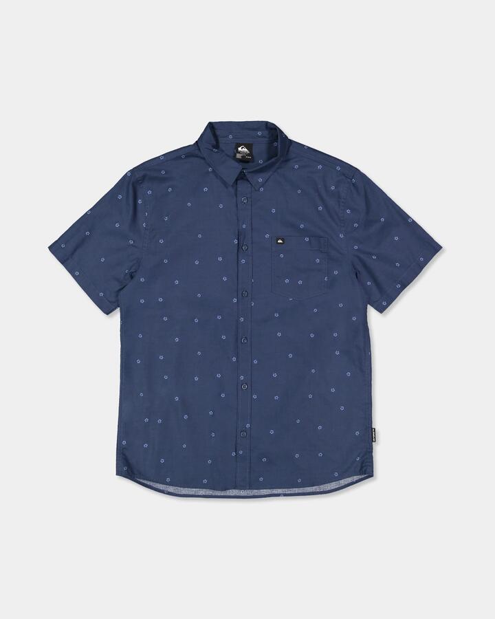Image of a model wearing Tops. Product name - Quiksilver Mens Apero Classic Short Sleeve Shirt Dark Denm Ditsy Hibiscus Wove in Dark Denm Ditsy Hibiscus Wove colour by brand - Quiksilver