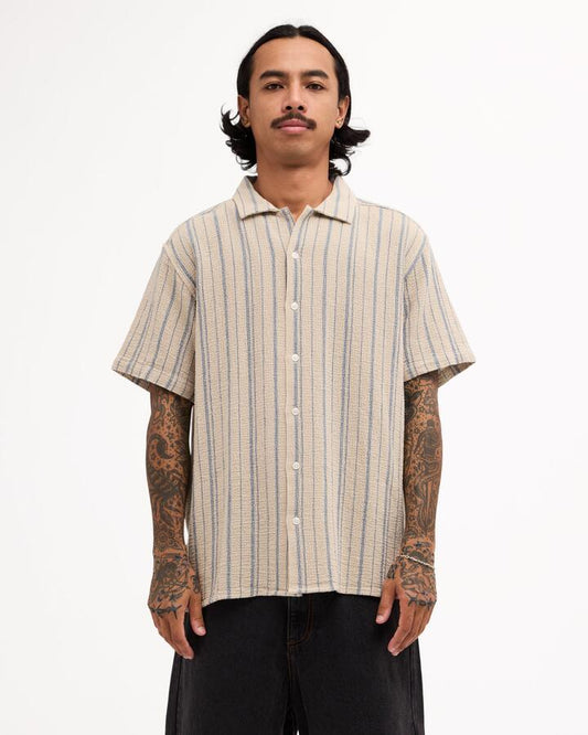 Image of a model wearing Tops. Product name - Rvca Mens Vacancy Stripe Short Sleeve Shirt Light Khaki in Light Khaki colour by brand - Rvca
