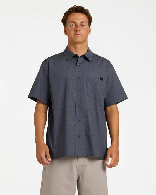 Image of a model wearing Tops. Product name - Billabong Mens Spec Mogul Short Sleeve Shirt Navy in Navy colour by brand - Billabong