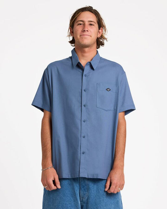 Image of a model wearing Tops. Product name - Quiksilver Mens Liquid Short Sleeve Shirt China Blue in China Blue colour by brand - Quiksilver