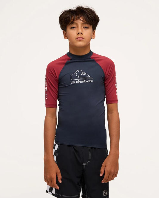 Image of a model wearing Tops. Product name - Quiksilver Boya 8-16 On Tour Short Sleeve Rash Vest Burnt Russet in Burnt Russet colour by brand - Quiksilver