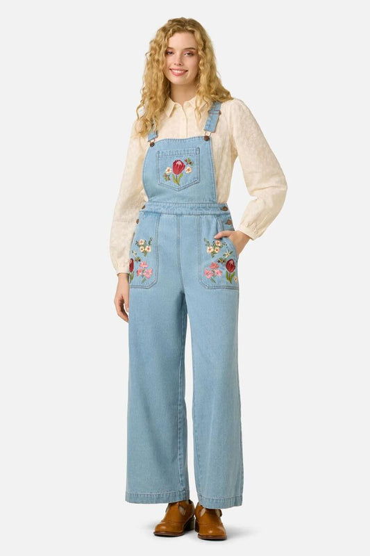 Image of a model wearing Pants. Product name - Native Flora Embroidered Overall in Light Denim colour by brand - Princess Highway