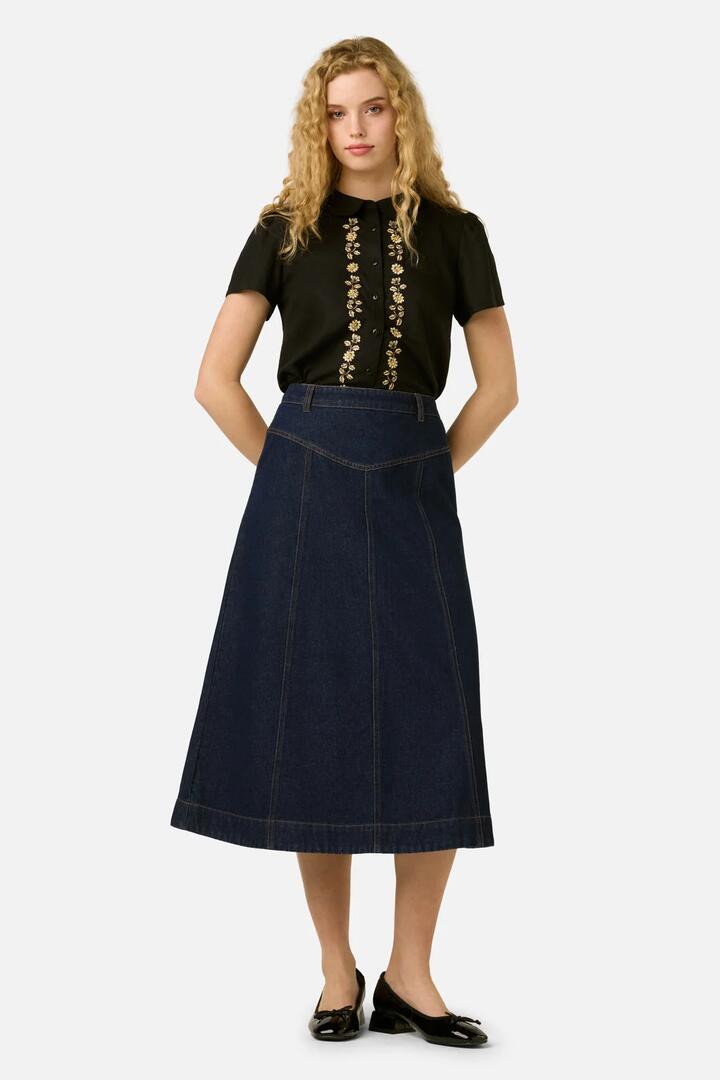 Image of a model wearing Skirts. Product name - Olinda Denim Midi Skirt in Blue Denim colour by brand - Princess Highway