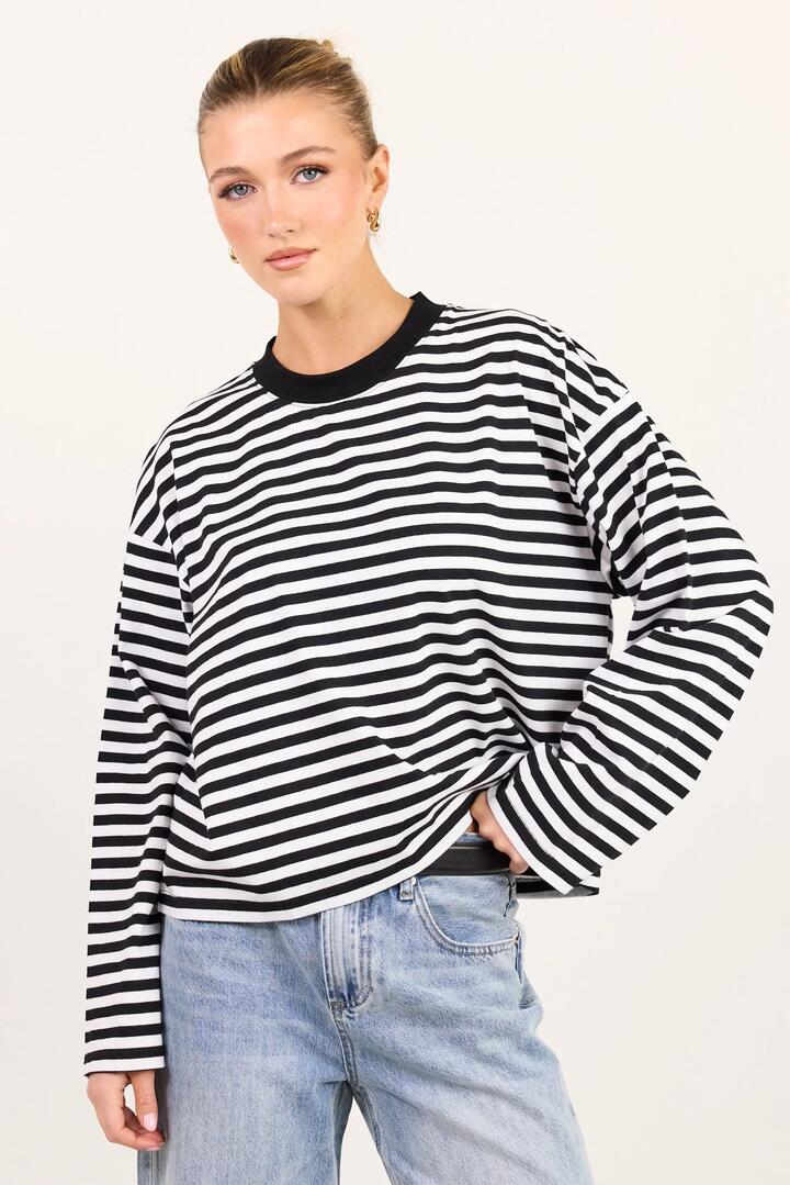 Image of a model wearing Tops. Product name - Unite Black White Stripe Long Sleeve Contrast Binding Boxy Tee in Black White Stripe colour by brand - Stories be Told