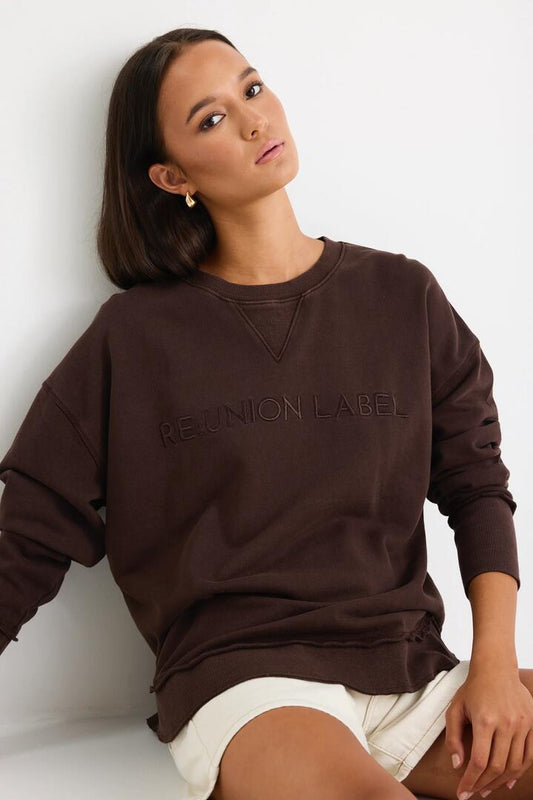 Image of a model wearing Outerwear. Product name - Scribe Chocolate Re:Union Sweatshirt in Chocolate colour by brand - RE:UNION Label