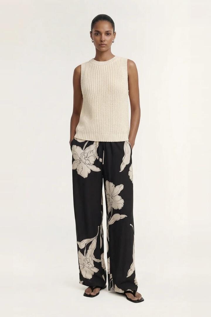Image of a model wearing Pants. Product name - Veda Black Cream Floral Relaxed Pant in Black colour by brand - Staple The Label