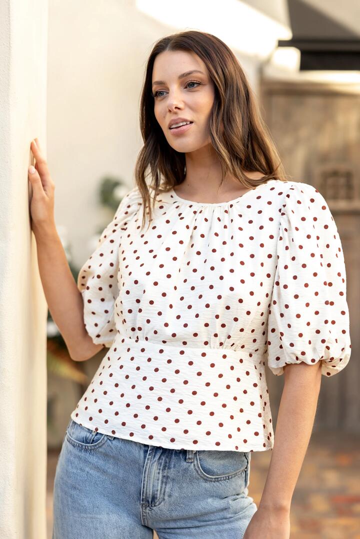 Image of a model wearing Tops. Product name - Eventual Ivory Chocolate Polka Dot Mid Sleeve Fit and Flare Top in Ivory Chocolate Polka Dot colour by brand - Stories be Told