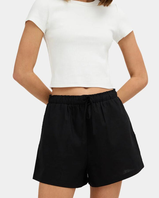 Image of a model wearing Shorts. Product name - Nunui Womens Roam Elastic Waist Shorts Black in Black colour by brand - Nunui