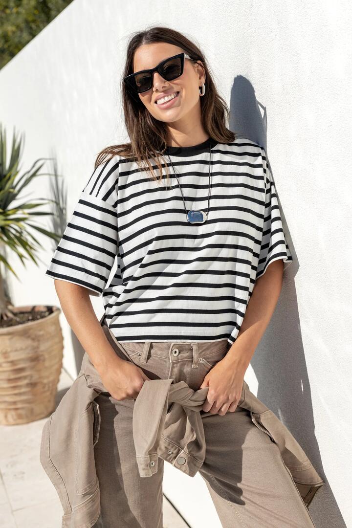 Image of a model wearing Tops. Product name - Cohesion Black White Stripe Oversized Contrast Binding Boxy SS Tee in Black White Stripe colour by brand - Stories be Told