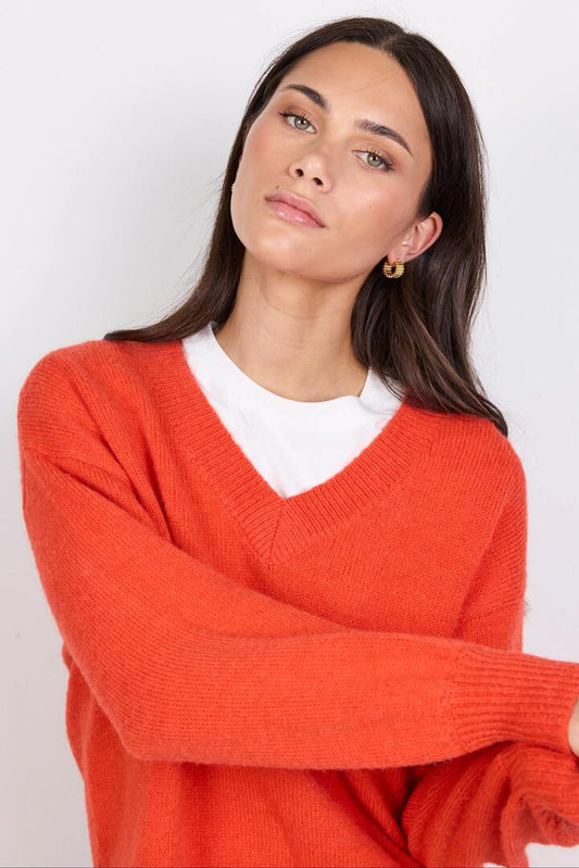 Image of a model wearing Outerwear. Product name - Harvest Blood Orange V Neck Knit Jumper in Blood Orange colour by brand - Ivy + Jack