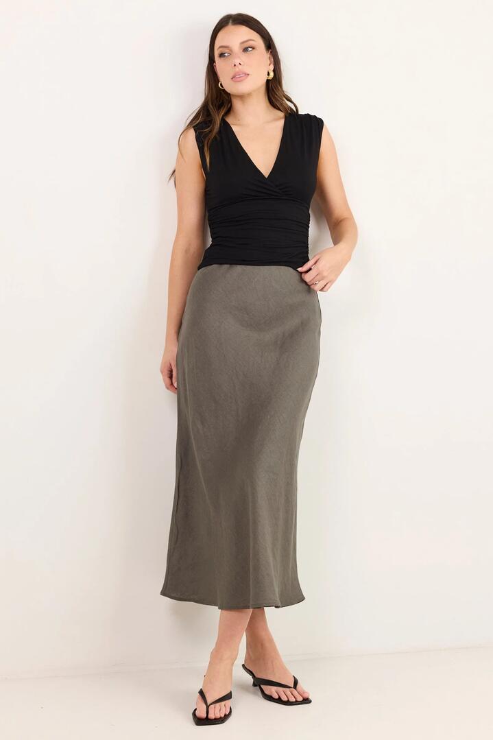 Image of a model wearing Skirts. Product name - Bliss Dark Olive Linen Bias Midi Skirt in Dark Olive colour by brand - RE:UNION Label