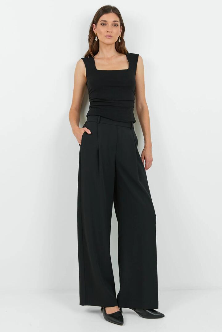 Image of a model wearing Pants. Product name - Business Black Wide Leg Pleat Front Pants in Black colour by brand - Among the Brave