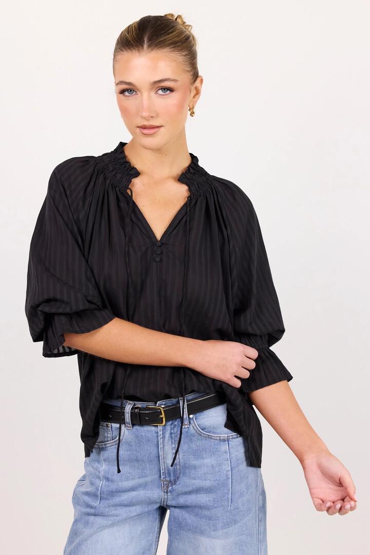 Image of a model wearing Tops. Product name - Expedition Black Self Stripe Shirred Neck Short Sleeve Top in Black Self Stripe colour by brand - Among the Brave