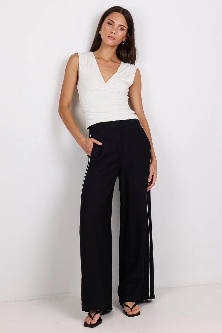 Image of a model wearing Pants. Product name - Exception Black Piped Side Pants in Black colour by brand - Among the Brave