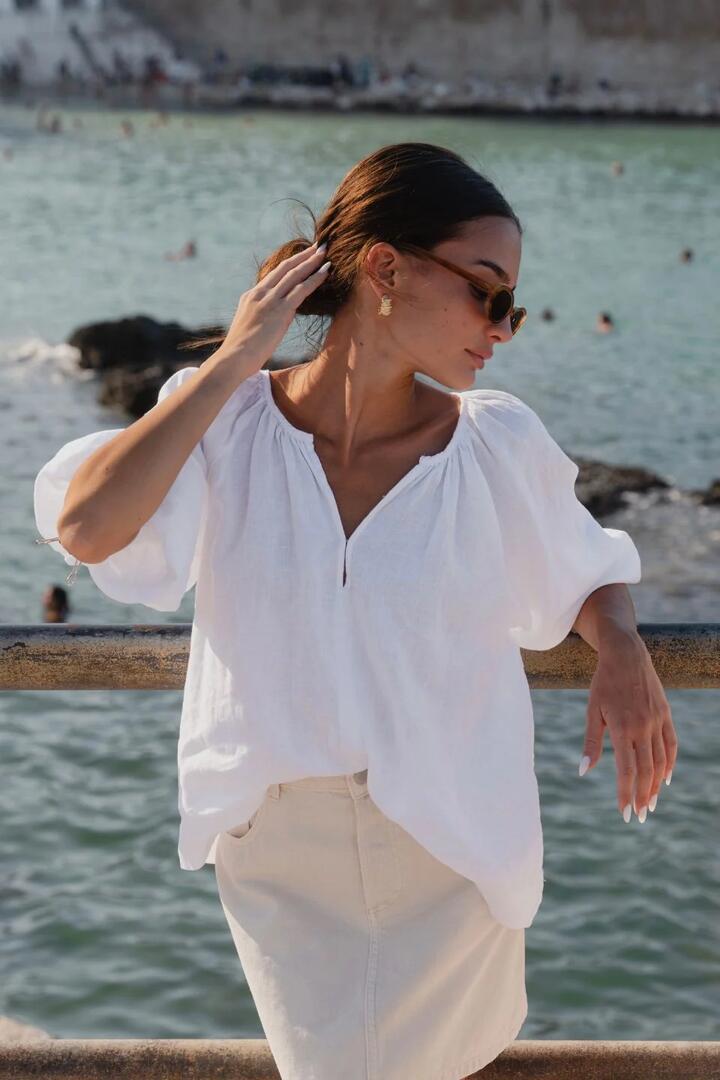 Image of a model wearing Tops. Product name - Revolutionary White Linen Relaxed LS Top in White colour by brand - RE:UNION Label