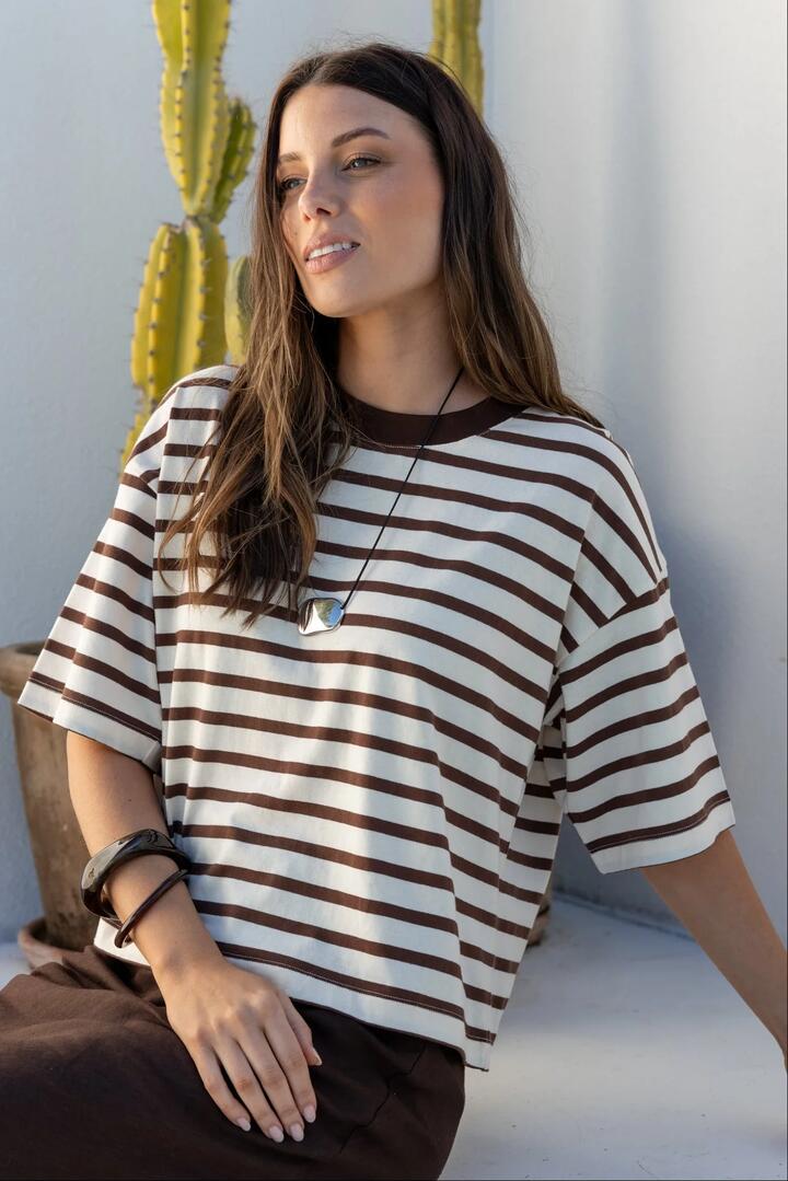 Image of a model wearing Tops. Product name - Cohesion Chocolate Vanilla Stripe Oversized Contrast Binding Boxy SS Tee in Chocolate Vanilla Stripe colour by brand - Stories be Told