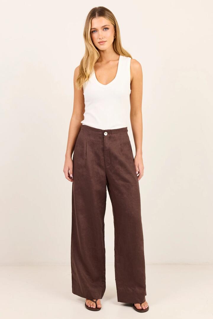 Image of a model wearing Pants. Product name - Curator Dark Chocolate Linen Pleat Front Wide Leg Pants in Dark Chocolate colour by brand - RE:UNION Label
