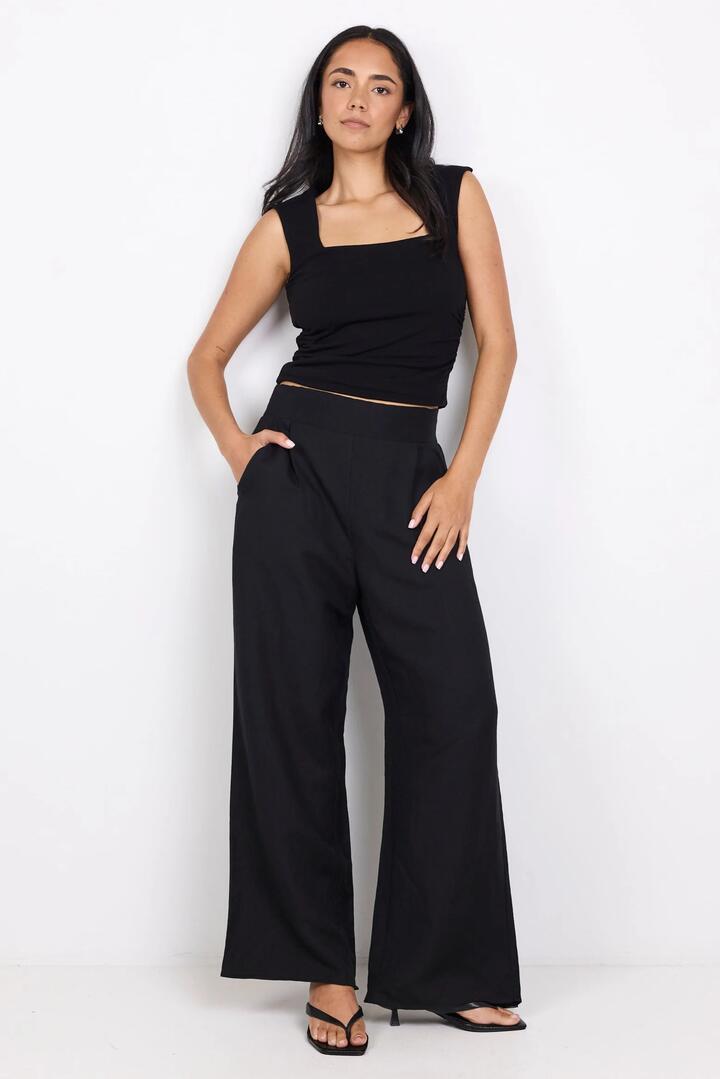 Image of a model wearing Pants. Product name - Guardian Black Petite Linen Viscose Elastic Back Pants in Black colour by brand - Among the Brave