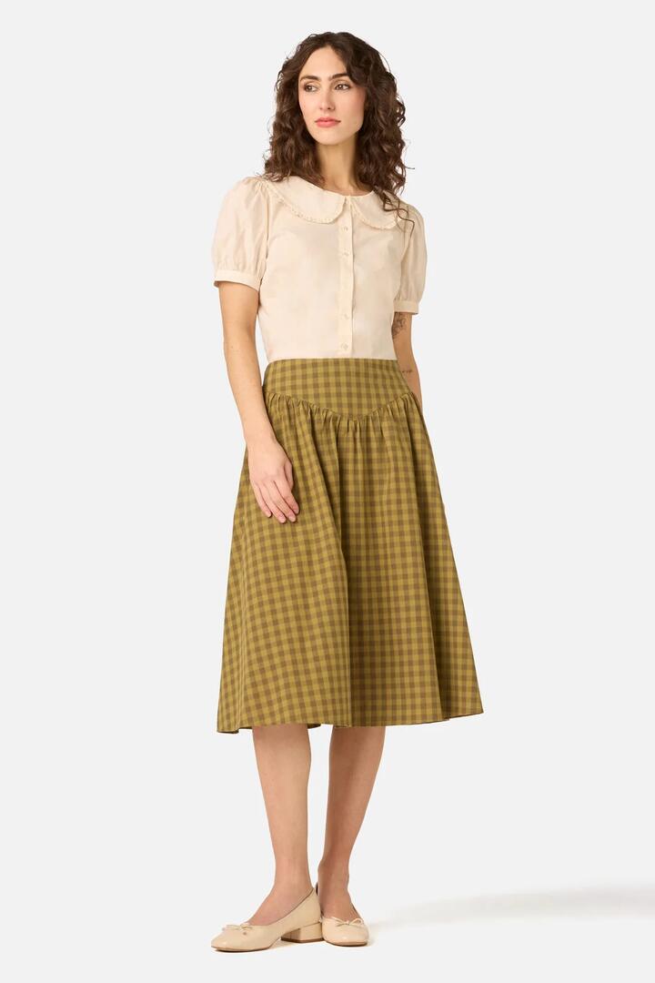 Image of a model wearing Skirts. Product name - Billie Check Yoke Midi Skirt in Olive colour by brand - Princess Highway