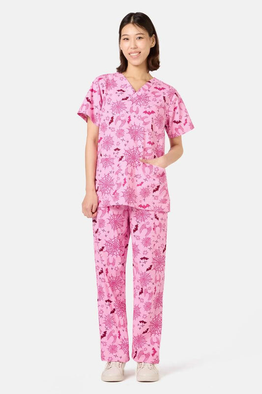 Image of a model wearing Uniforms & Workwear. Product name - Spooky Season Scrub Set in Pink colour by brand - Scrubs With Love