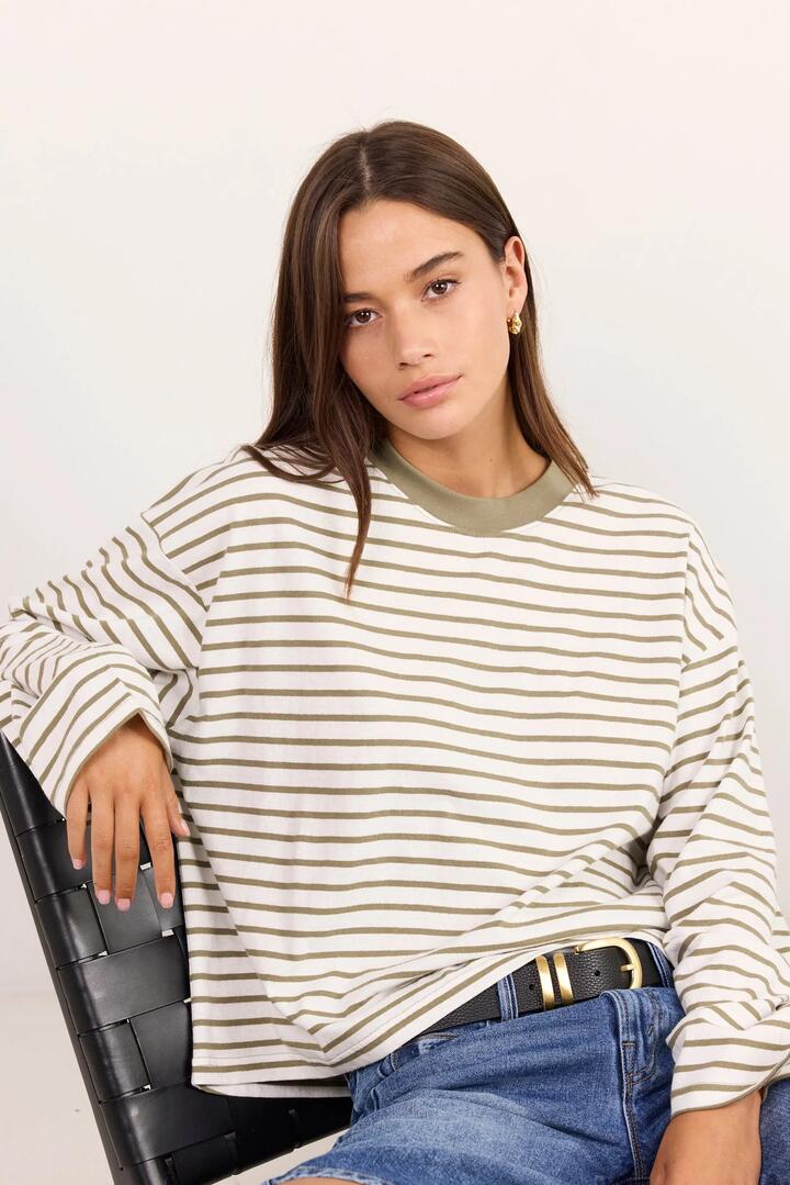Image of a model wearing Tops. Product name - Unite Khaki White Stripe Long Sleeve Contrast Binding Boxy Tee in Khaki White Stripe colour by brand - Stories be Told