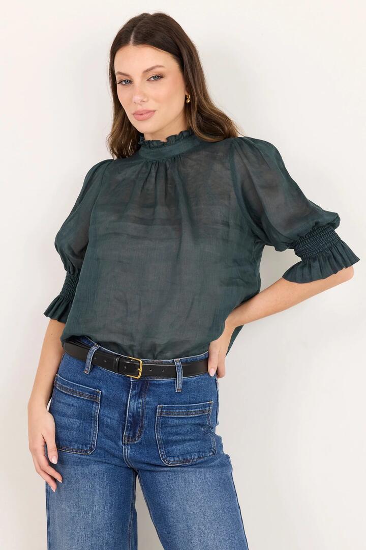 Image of a model wearing Tops. Product name - Verse Petrol Sheer High Neck Short Sleeve Top in Petrol colour by brand - By Rosa.