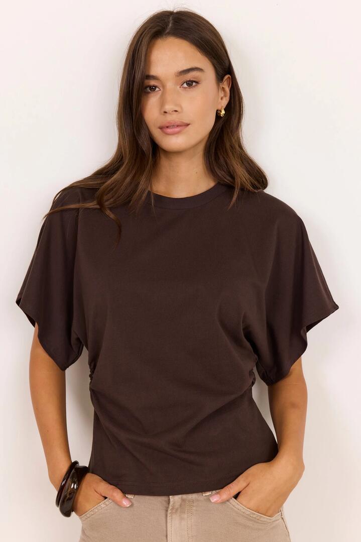 Image of a model wearing Tops. Product name - Cadence Chocolate Cotton Gathered Waist Detail Short Sleeve Tee in Chocolate colour by brand - RE:UNION Label