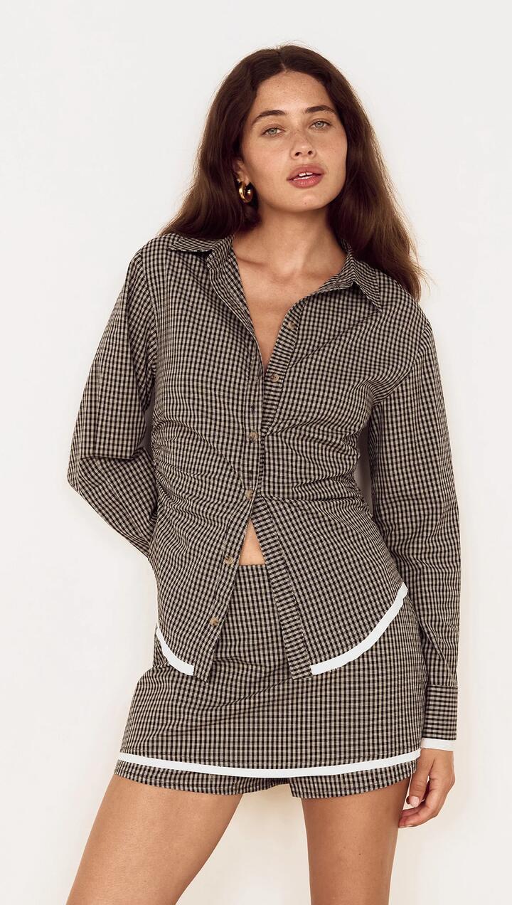 Image of a model wearing Skirts. Product name - Contrast Hem Mini Skirt in Grey Check in Check colour by brand - MINKPINK