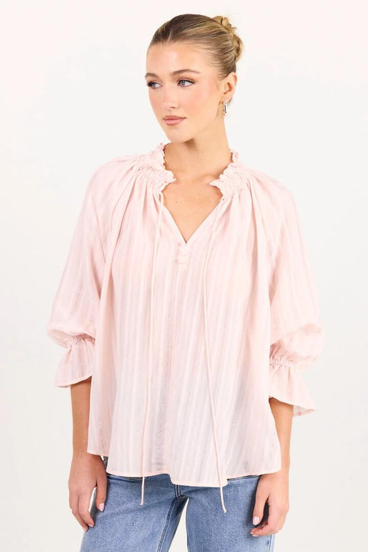 Image of a model wearing Tops. Product name - Expedition Blush Self Stripe Shirred Neck Short Sleeve Top in Blush Self Stripe colour by brand - Among the Brave