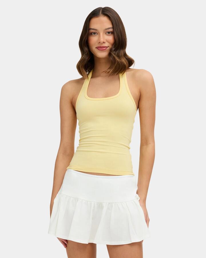 Image of a model wearing Tops. Product name - Nunui Womens Hug Me Halter Tank Top Butter in Butter colour by brand - Nunui
