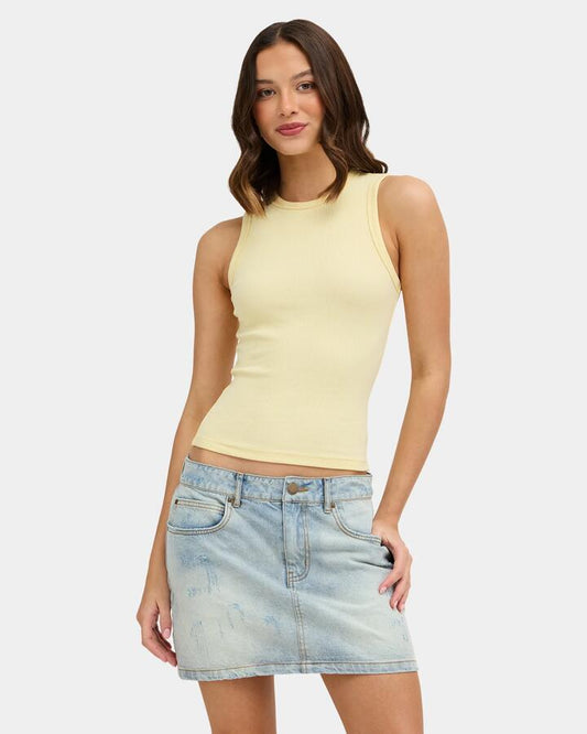 Image of a model wearing Tops. Product name - Nunui Womens Zander Tank Top Butter in Butter colour by brand - Nunui
