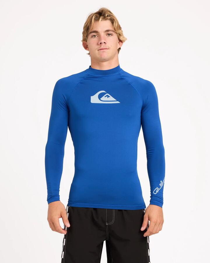 Image of a model wearing Tops. Product name - Surf Dive 'n Ski Mens All Time Upf 50 Long Sleeve Rashguard Monaco Blue in Monaco Blue colour by brand - Surf Dive 'n Ski