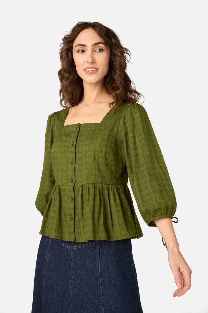 Image of a model wearing Tops. Product name - Eveleigh Peplum Top in Olive colour by brand - Princess Highway