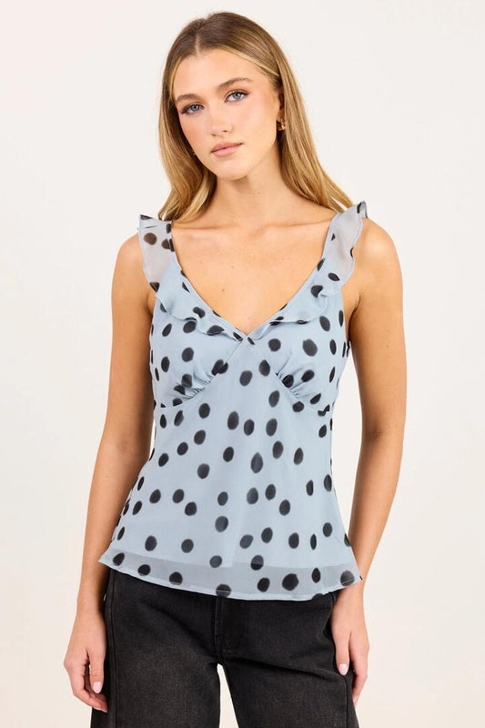 Image of a model wearing Tops. Product name - Crave Ice Blue Polka Dot Georgette Ruffle Neck Cami Top in Ice Blue Polka Dot colour by brand - Georgia Zoe