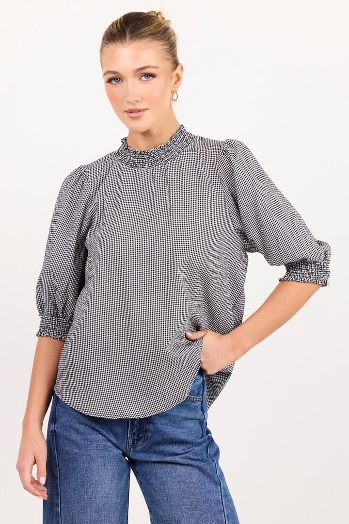 Image of a model wearing Tops. Product name - Influential Black White Mini Gingham High Neck Top in Black Grey Mini Gingham colour by brand - Among the Brave