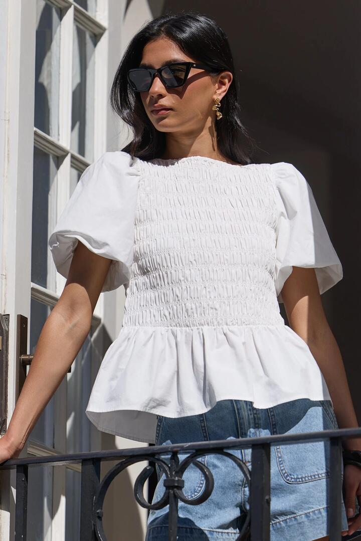 Image of a model wearing Tops. Product name - Artifact Ivory Poplin Shirred Bubble Sleeve Top in Ivory colour by brand - Stories be Told