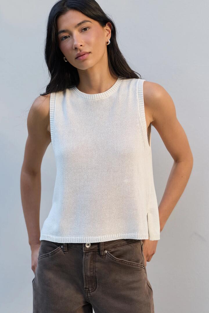 Image of a model wearing Outerwear. Product name - Salute Ivory Relaxed Sleeveless Knit Top in Ivory colour by brand - Among the Brave