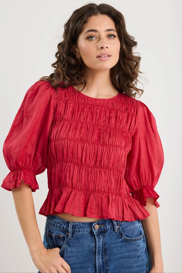 Image of a model wearing Tops. Product name - Melodic Red SS Shirred Body Top in Red colour by brand - Ivy + Jack