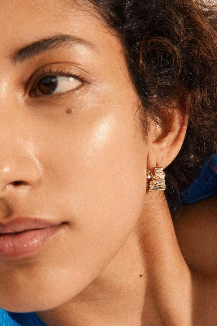 Image of Jewelry. Product name - Willpower Wavy Recycled EOL Gold Plated Huggie Hoop Earrings in Gold colour by brand - Pilgrim