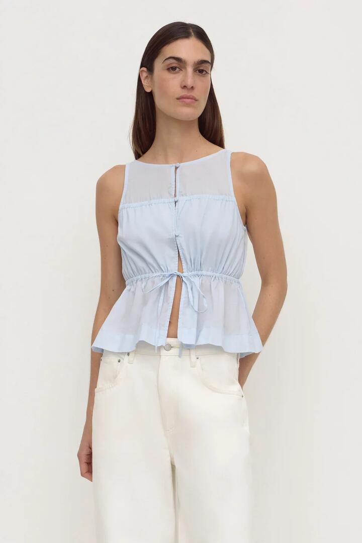 Image of a model wearing Tops. Product name - Suzie Powder Blue Sleeveless Top in Blue colour by brand - Assembly Label
