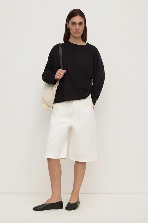 Image of a model wearing Shorts. Product name - Relaxed Antique White Denim Short in White colour by brand - Assembly Label