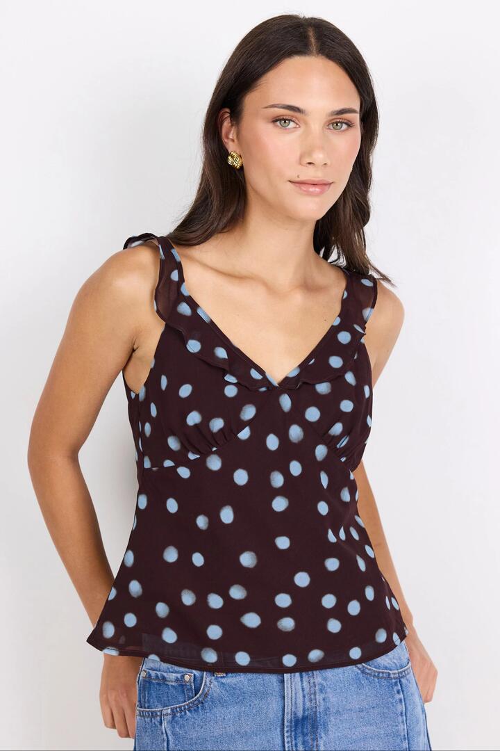 Image of a model wearing Tops. Product name - Crave Chocolate Blue Polka Dot Georgette Ruffle Neck Cami Top in Chocolate Blue Polka Dot colour by brand - Georgia Zoe