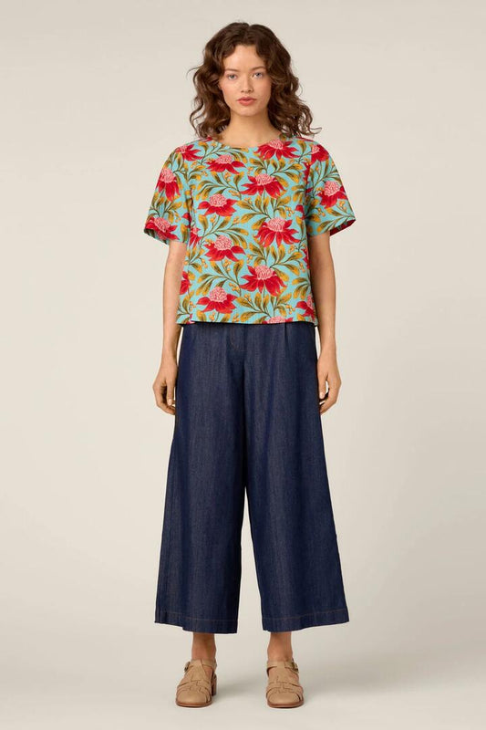 Image of a model wearing Tops. Product name - Waratah Short Sleeve Top in Teal colour by brand - Princess Highway