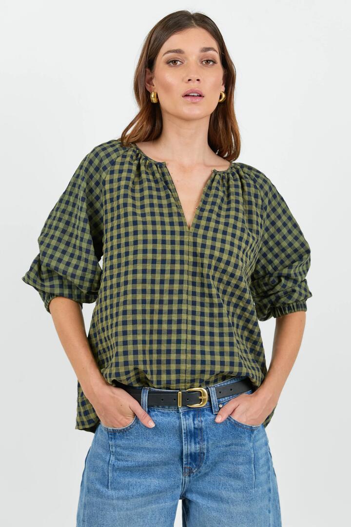 Image of a model wearing Tops. Product name - Revolutionary Khaki Ink Gingham Linen Relaxed LS Top in Khaki Ink Gingham colour by brand - RE:UNION Label