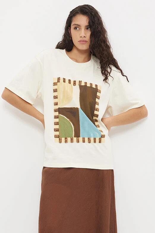 Image of a model wearing Tops. Product name - Essence White Abstract Painterly Oversized Beaded SS Tee in White colour by brand - Mon Renn