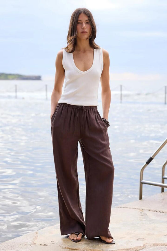 Image of a model wearing Pants. Product name - Wellness Dark Chocolate Linen Pull On Wide Leg Pants in Dark Chocolate colour by brand - RE:UNION Label