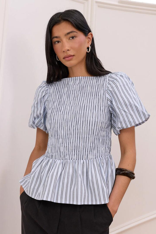 Image of a model wearing Tops. Product name - Artifact Pale Blue Stripe Shirred Bubble Sleeve Top in Pale Blue Stripe colour by brand - Stories be Told